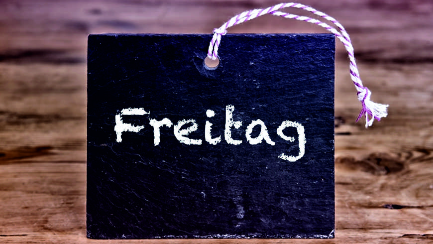 the german word for Friday written on chalk board on wooden table